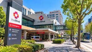 A hospital entrance with clear signage for emergency, main entrance, admissions, car park, and deliveries. - Spacious 70m² St Kilda Rd Stay Near Alfred Hospital with Gym,Parking & Workspace (Melbourne)