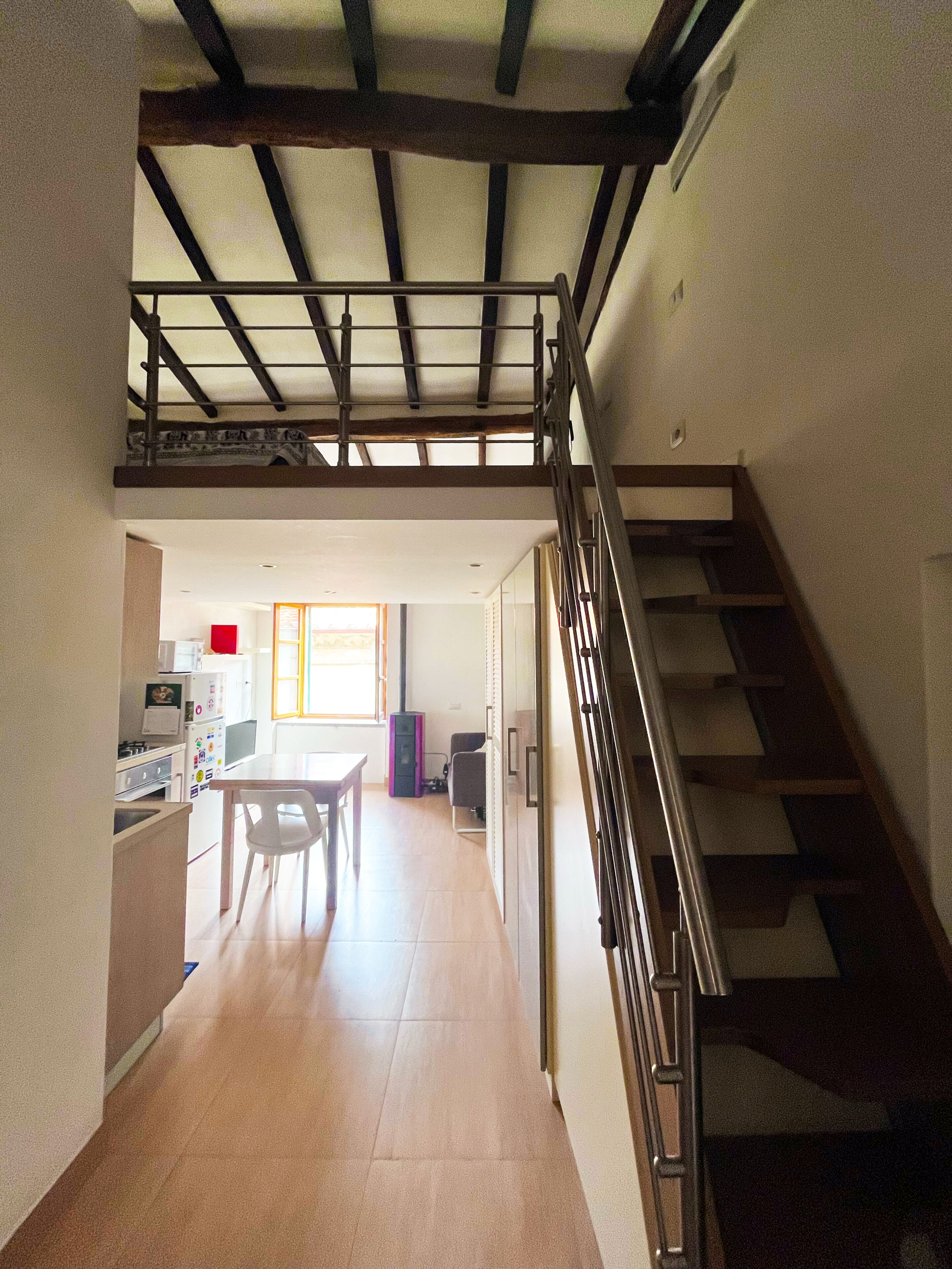 Cozinha espaçosa com área de jantar, escada e vista para a sala de estar.