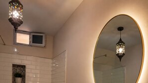 A bathroom with a marble sink, a toilet, a bidet, a mirror, and a decorative light fixture. - 2-bedroom apartment in charming Menzel Jemil with AC (Menzel Jemil)