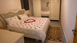 A bedroom with a bed, a bedside table, a wardrobe, and a mirror. - 2-bedroom apartment in charming Menzel Jemil with AC (Menzel Jemil)