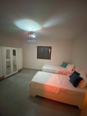 Quarto com cama, guarda-roupa, janela e luminária no teto.