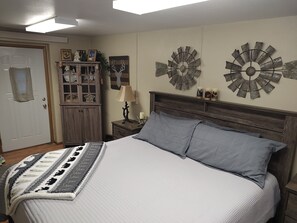 Una camera da letto con un letto, un armadio in legno, una lampada e decorazioni a parete.