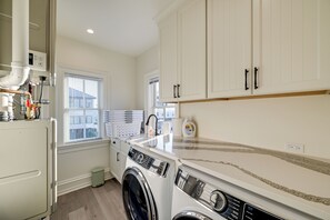 A laundry room with a front-loading washing machine, a sink, and a window with blinds. - Beach in Your Backyard! Seaside Strathmere Estate (Strathmere)