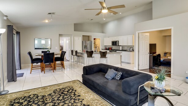 A spacious living area with a dark sofa, a glass coffee table, and a patterned rug. - Private Pool & Spa: North Las Vegas Retreat! (North Las Vegas)