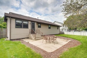 A single-story house with a patio area, a small deck, and a fenced backyard. - Explore Dtwn & Route 66 History! Cozy Joliet Home (Joliet)
