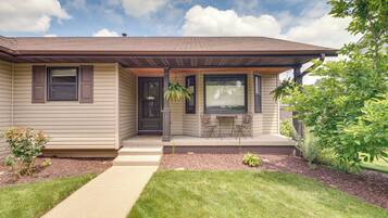 A single-story house with a front porch, a small garden, and a clear sky.