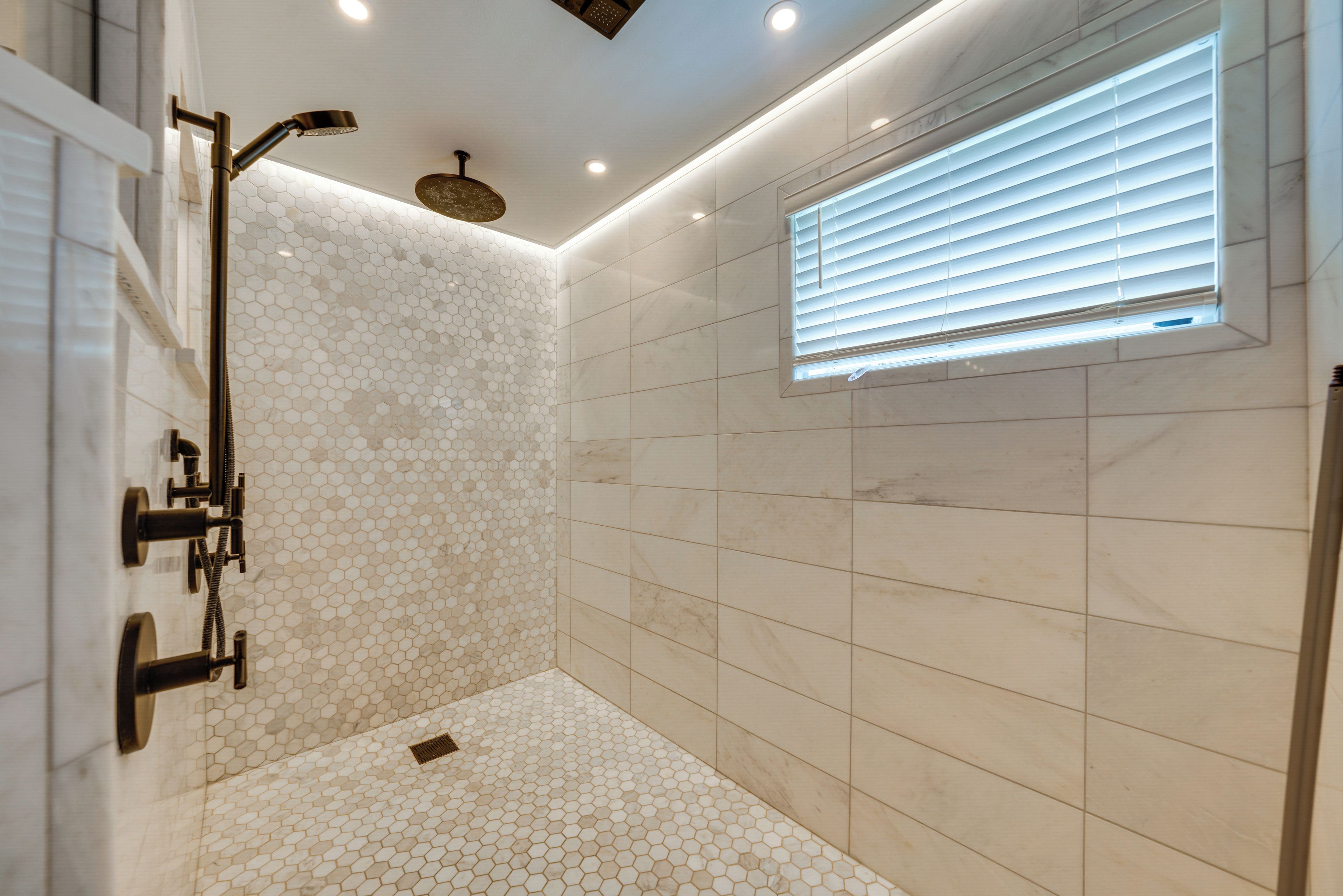 Une salle de bain moderne équipée d’une douche, de toilettes et d’une fenêtre avec stores.
