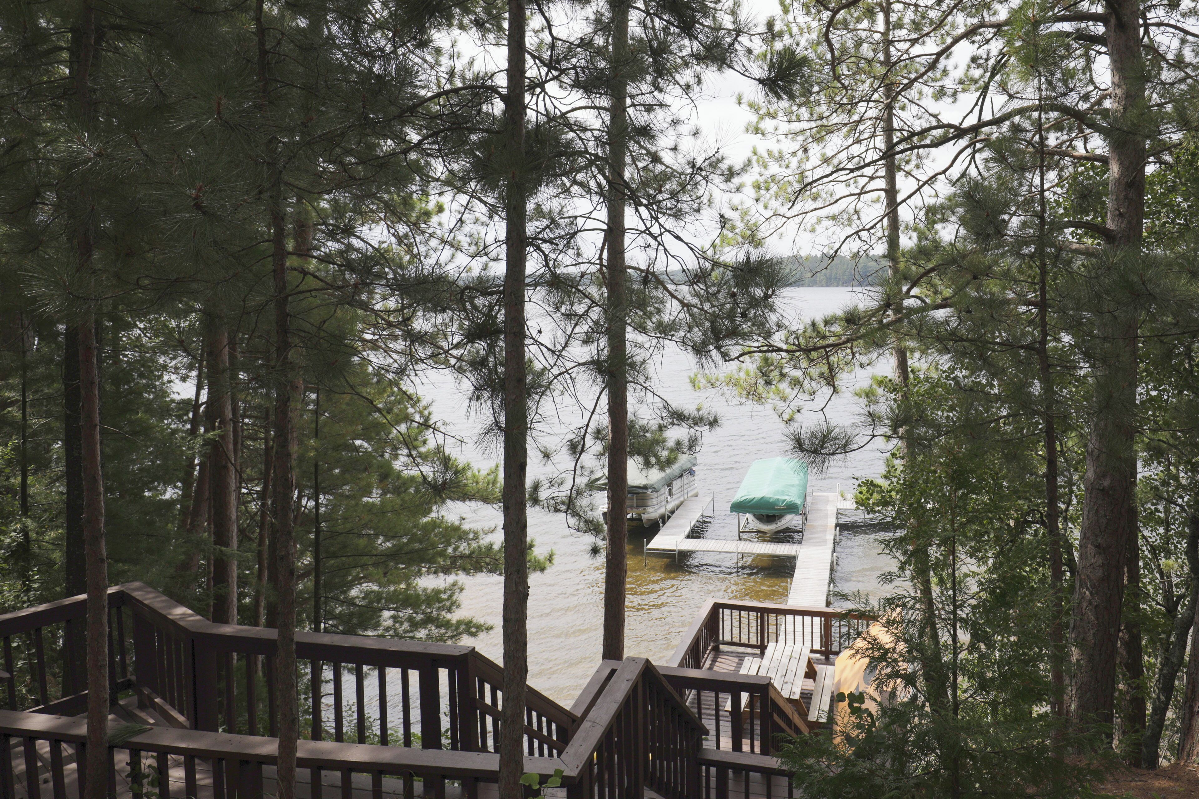 A wooden deck with a view of a lake and docked boats.