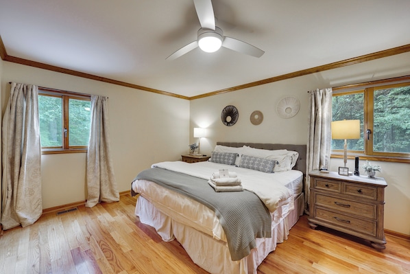 A bedroom with a bed, nightstand, dresser, and a ceiling fan.