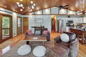 A spacious living area with a wooden ceiling, a dining area, and a kitchen with modern appliances.