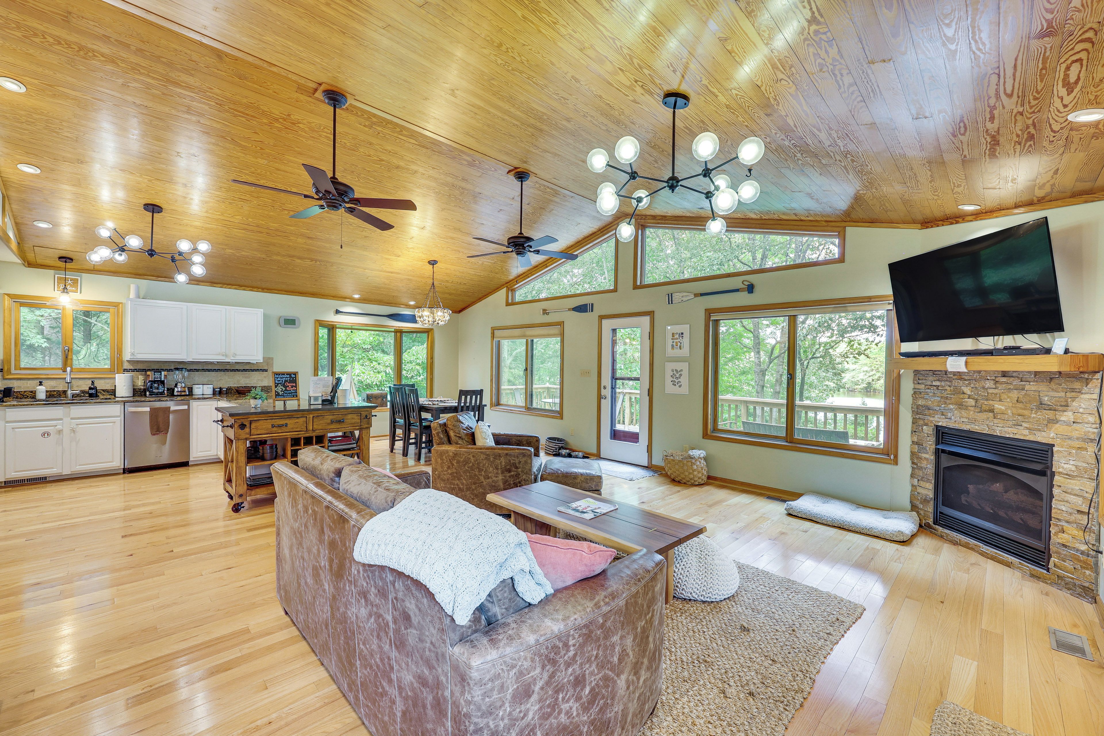 A spacious living area with a fireplace, a television, and a large window overlooking the outdoors.