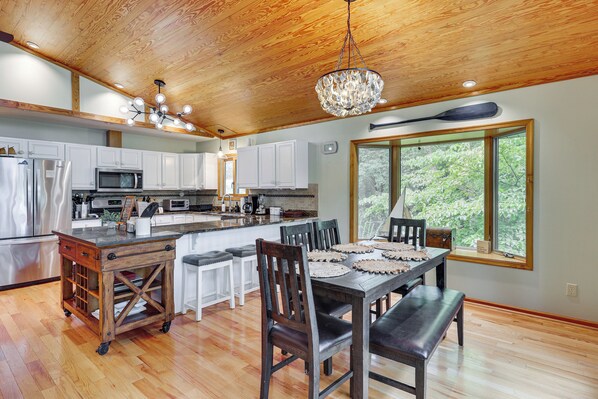 A modern kitchen with white cabinets, stainless steel appliances, and a large island with bar stools.