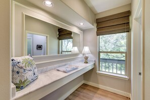 A bathroom with a vanity, a mirror, a window with blinds, and a towel with a floral pattern. - Bayou Views & Boat Dock on 12 Private Acres (Dickinson)