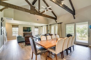 A spacious dining area with a wooden table and chairs, a television, and a fireplace. - Bayou Views & Boat Dock on 12 Private Acres (Dickinson)