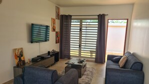 A living room with a sofa, a coffee table, a TV, and artwork on the wall. - Beautiful villa in Porto-Novo Benin (Porto-novo)