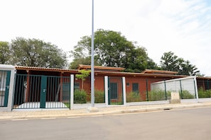 Un edificio residenziale con cancello automatico, vialetto lastricato e strada di fronte.