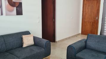 A living room with two sofas, a coffee table, a remote control, and a tissue box.