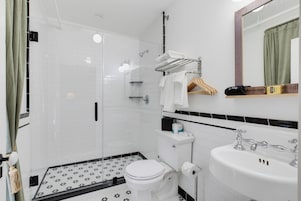 A modern bathroom with a shower, toilet, and sink.