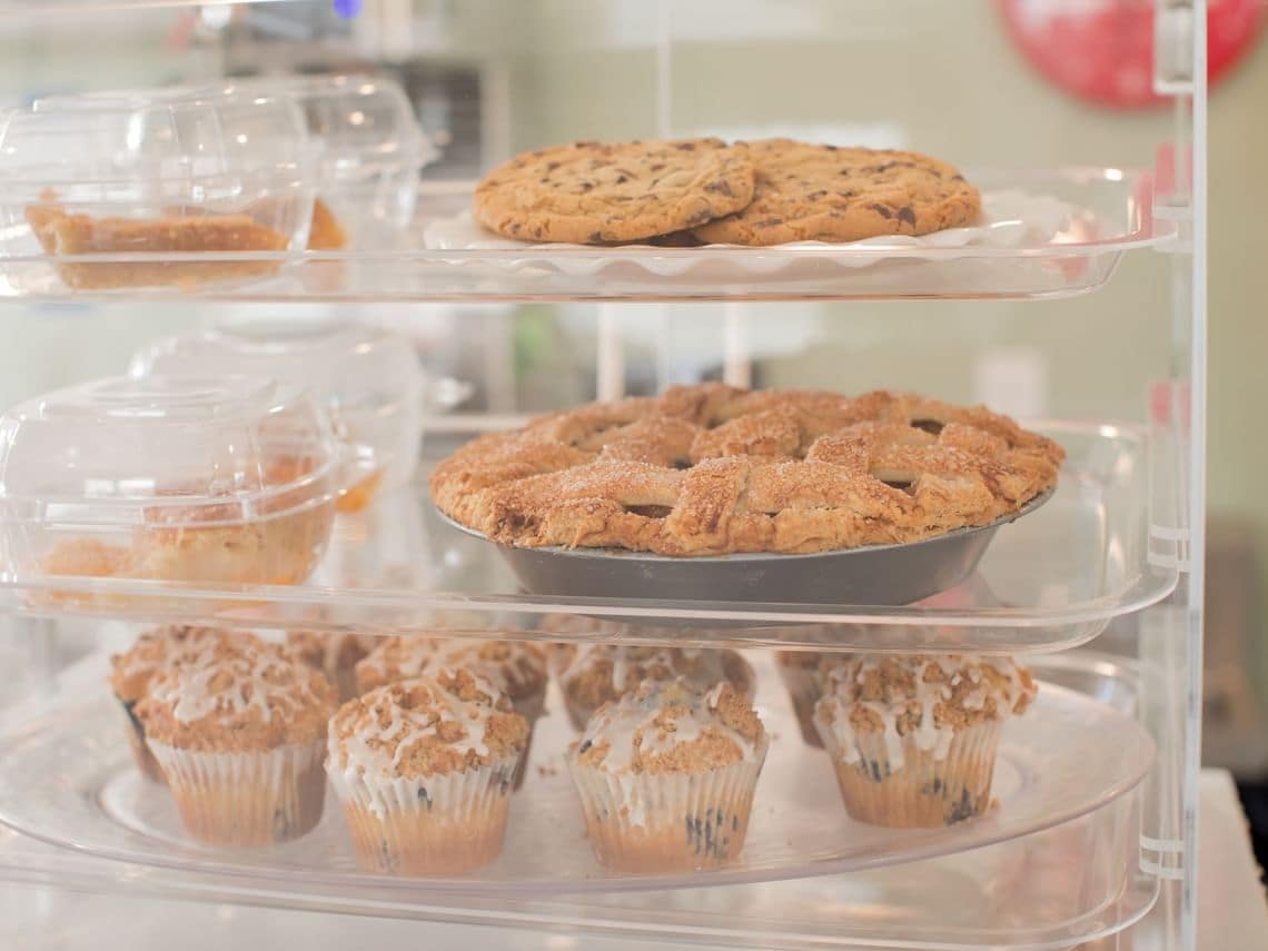 Een vitrine met diverse gebakjes, waaronder koekjes en muffins.