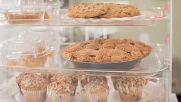 Een vitrine met diverse gebakjes, waaronder koekjes en muffins.