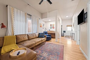 A modern living room with a leather sofa, a coffee table, and a patterned rug.