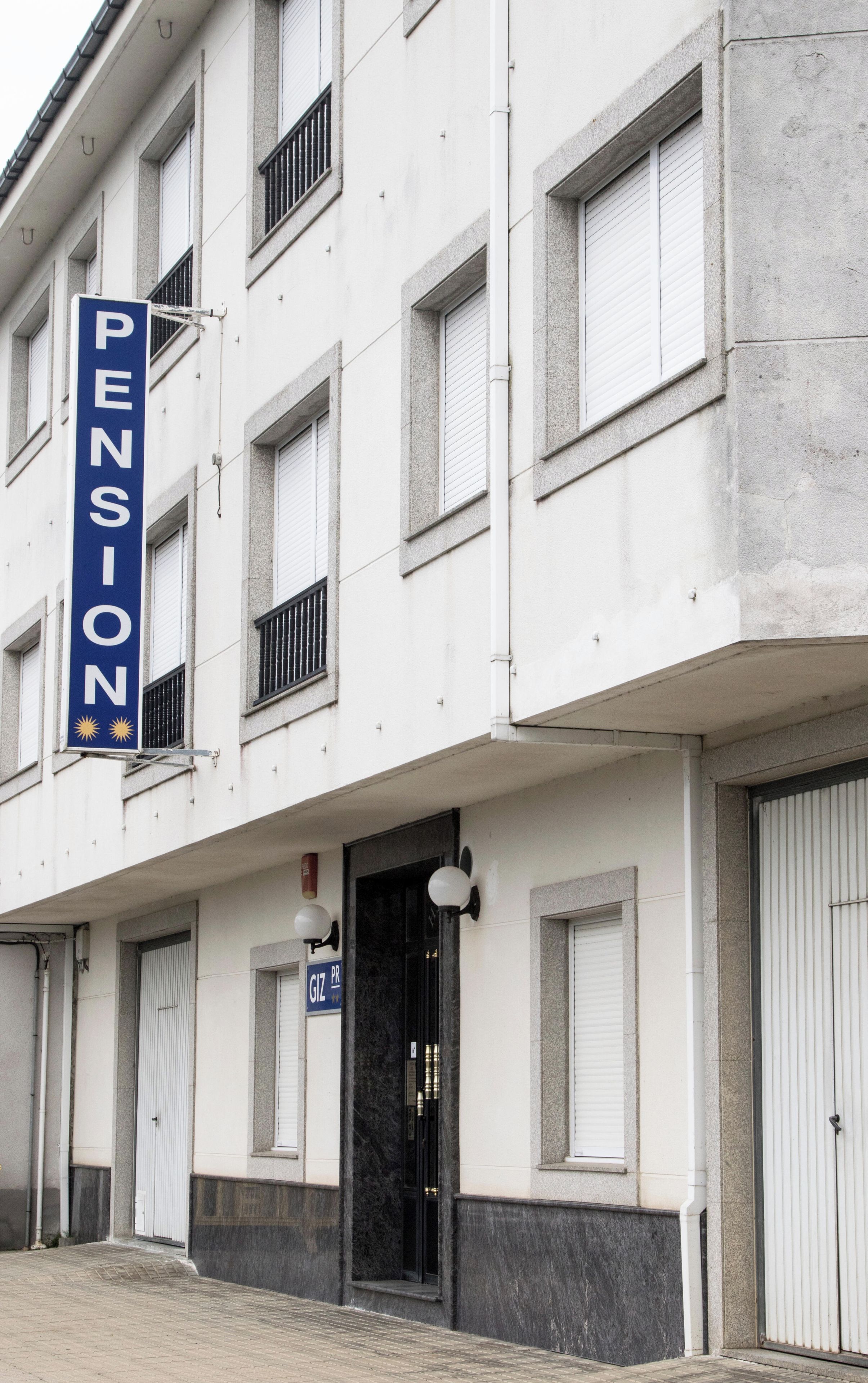 Un bâtiment avec une enseigne indiquant « PENSION » et une porte portant l’inscription « GIZ PR ».
