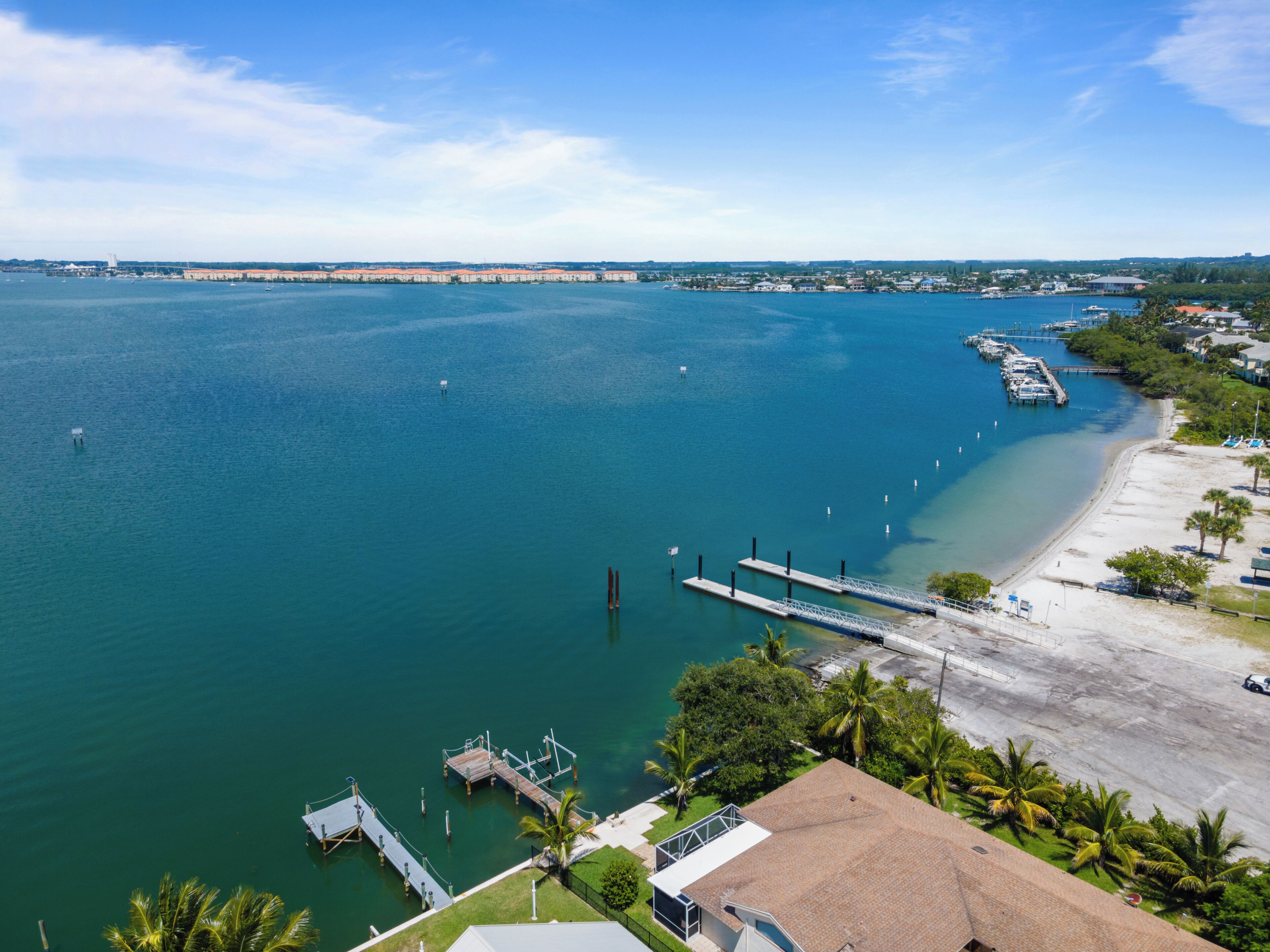 Une vue sur la côte, avec un port de plaisance, une plage de sable et des immeubles résidentiels.