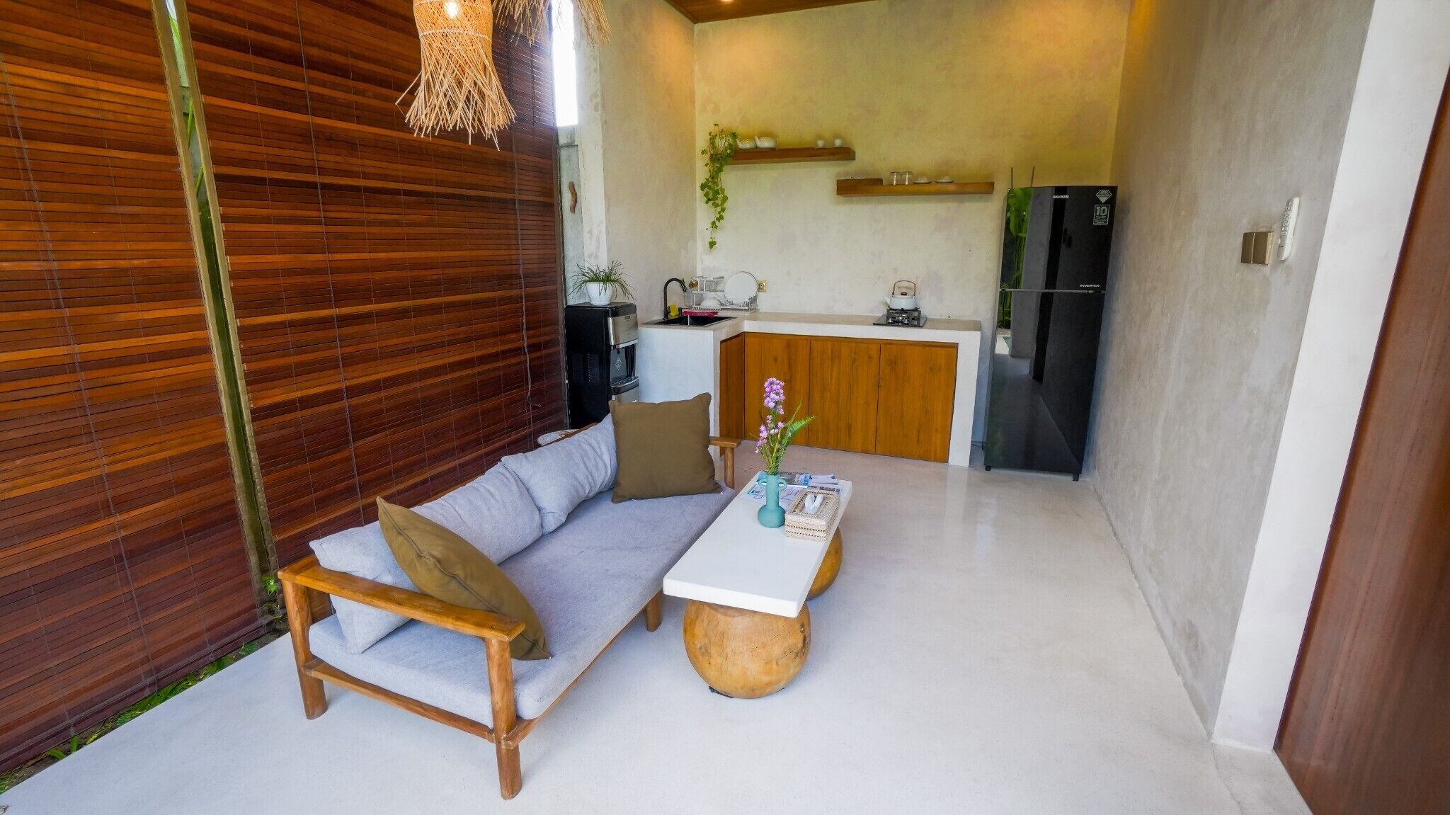 Un espacio habitable compacto con sofá, mesita de centro y zona de kitchenette.