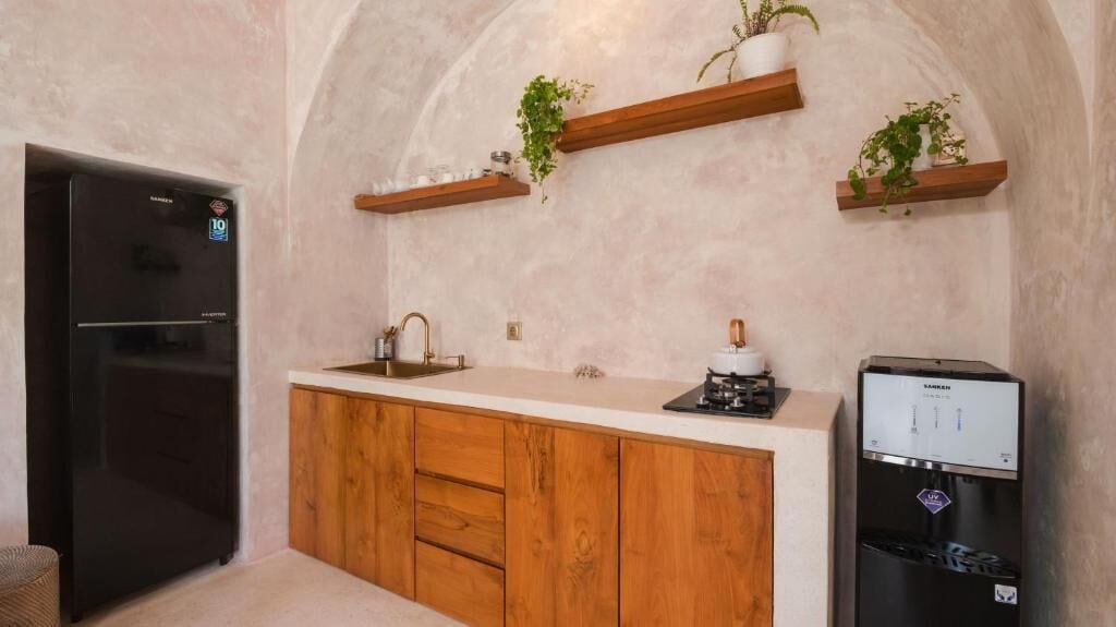 A kitchen with wooden cabinets, a built-in oven, a refrigerator, and a water dispenser.
