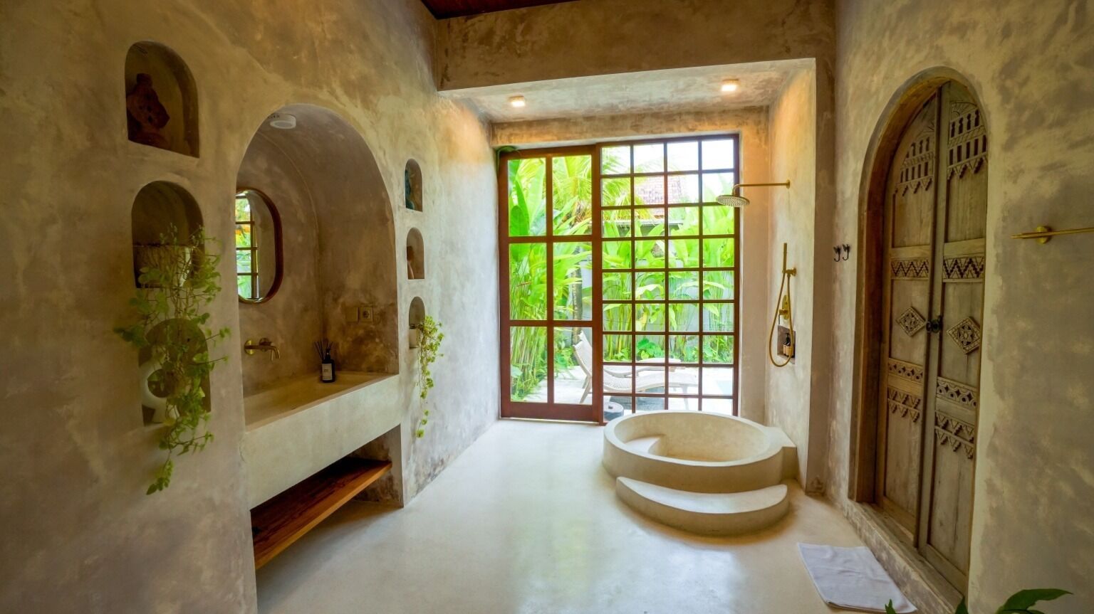A bathroom with a bathtub, a window, and a door.