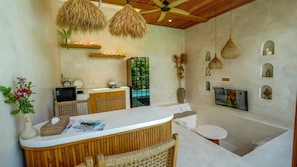 A modern kitchen with a white countertop, wooden accents, and a TV mounted on the wall. - Nick Villas (Ubud)