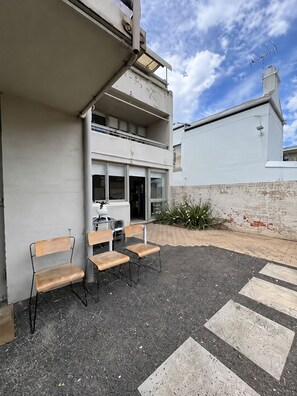 Ein Gebäude mit flacher Fassade, einem Balkon und einer Fußgängerampel.