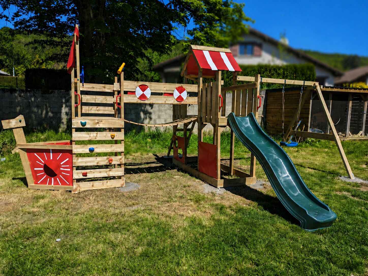 Un parc infantil de fusta amb tobogan i elements per pujar.