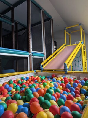 A play area with a ball pit and a slide structure.