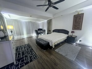 A modern bedroom with a bed, desk, chair, and a ceiling fan. - Jomtien beach center point, direct sea-view, THE best location! (Muang Pattaya)