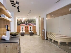 A modern spa room with a wooden reception desk, a large mural of a waterfall, and a sauna area with benches. - Lovely apartment for 6 guests with pool, WIFI, TV, balcony and pets allowed (Viehhofen)