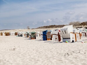 A row of beach huts with the name 'WITT' on them, arranged on a sandy beach. - Holiday Apartment F5 (Graal Mueritz)