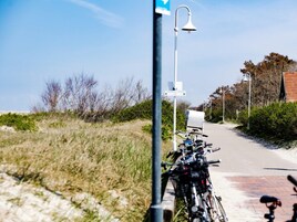 Un camino con bicicletas estacionadas al lado, una farola y un cielo despejado.