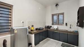 A compact kitchen with a refrigerator, stove, and sink.