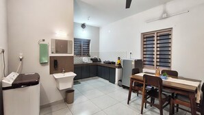 Una cocina compacta con lavamanos, encimera y zona de comedor con sillas y una mesa.