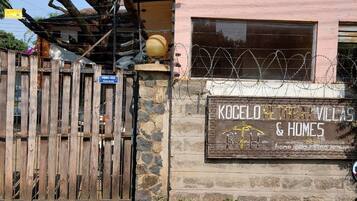 En bygning med et skilt, der viser 'KOCELO RETREAT & HOME', og en træport.