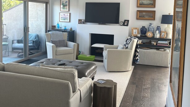 Ein modernes Wohnzimmer mit Flachbildfernseher, Sofas, Couchtisch und Kamin.