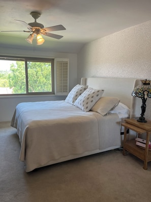 A bedroom with a bed, a nightstand, a lamp, a ceiling fan, and a window with blinds. - Beautifully remodeled and furnished Spacious 3 condo in Oaks North 55+ Community (San Diego)