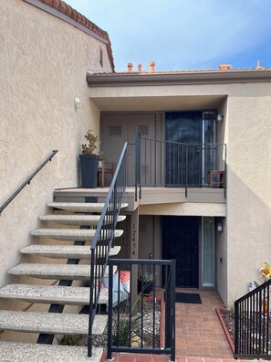 A residential building with a staircase, a balcony, and a door with a number.