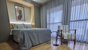 Ein modernes Hotelzimmer mit einem großen Bett, einem kleinen Tisch und einem Stuhl.