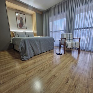 Een moderne hotelkamer met een groot bed, een kleintje tafeltje en een stoel.