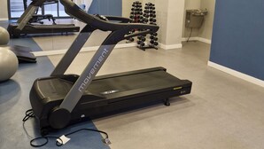 Ein Fitnessraum mit Laufbändern, Gymbällen und Kurzhanteln.