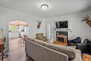 A modern living room with a sofa, a television, and a fireplace.