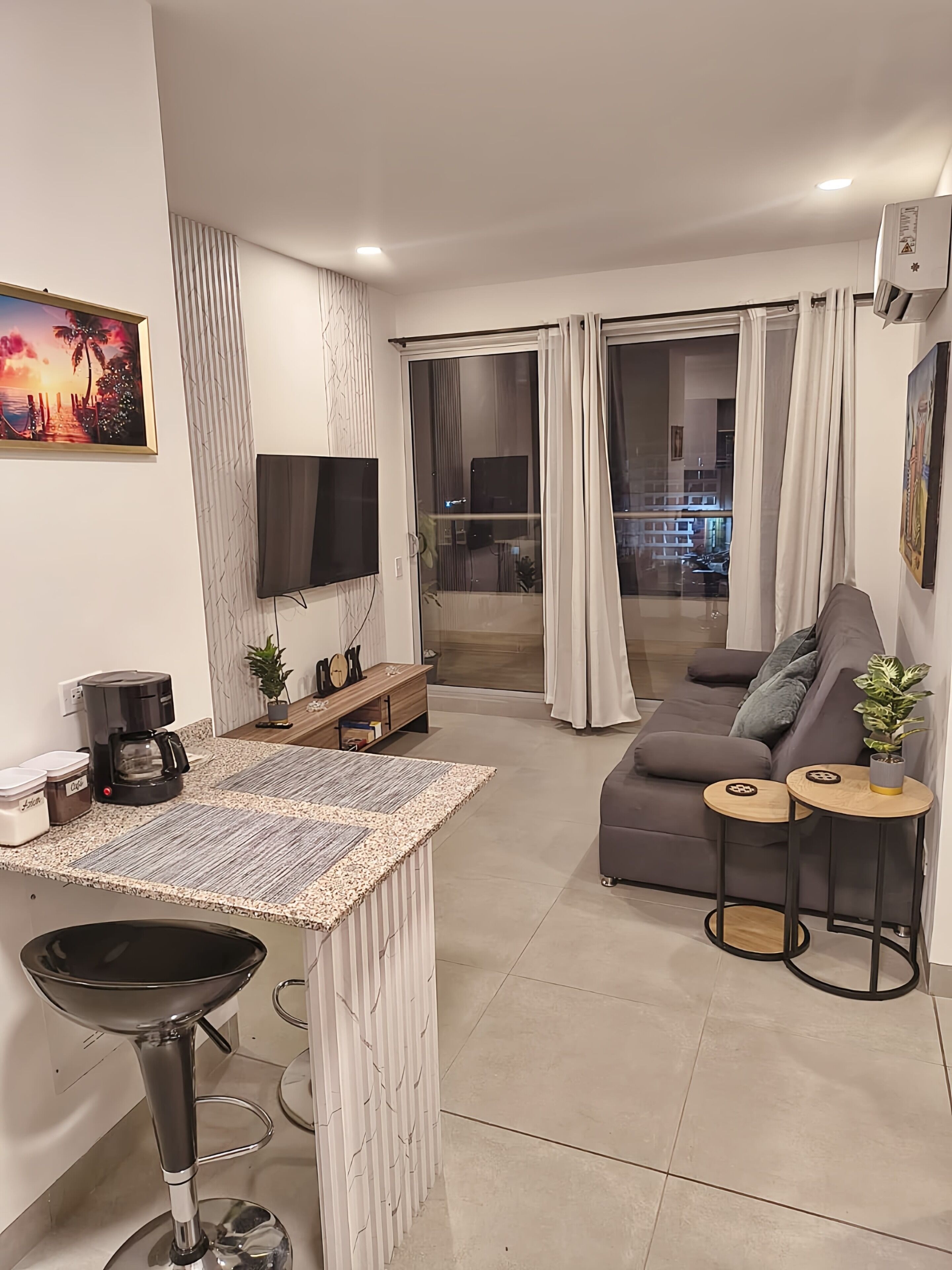 Un salon moderne avec un canapé, une table basse et un téléviseur fixé au mur.