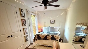 A bedroom with a bed, a desk, a chair, a ceiling fan, and string lights. - Oxford at its Best! Location, Layout, Privacy!! (Oxford)